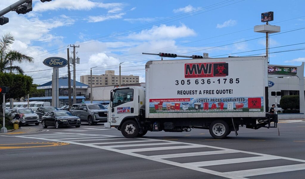 Medical Waste Inc. disposal truck on a scheduled pickup route through the streets of Orlando, Florida